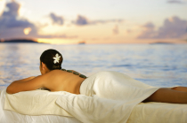 Frau auf Massageliege vor einem Gewässer